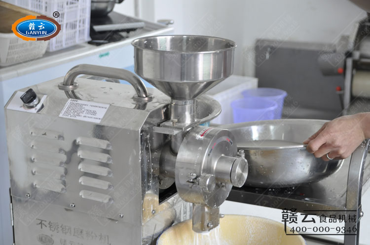 開機(jī)將浸泡過的大米慢慢倒入機(jī)器料斗內(nèi)